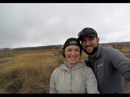 A smiling couple posing at Hawaii Volcanoes National Park on the Big Island during their honeymoon. 