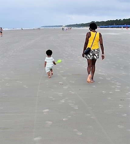 Grandma and grandson walking along the shoreline while on vacation at Ocean Oak Resort by Hilton Grand Vacations on Hilton Head Island, South Carolina. 