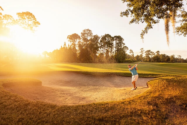 Man playing golf while on family vacation in Orlando Florida. 