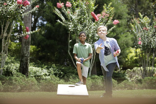 Young boys playing cornhole at a Hilton Grand Vacations Orlando resort.