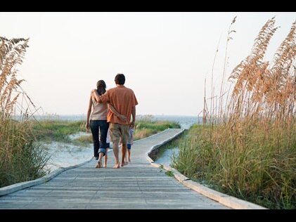 Family walking down the boardwalk toward the beach on Hilton Head Island in South Carolina.