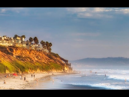 San Diego shoreline dotted with beach umbrellas in Southern California. 