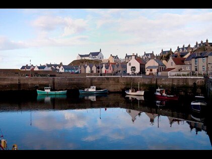 Quaint European bay with boats and small town in the background. 