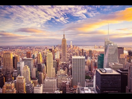 New York City skyline against pink painted skies. 