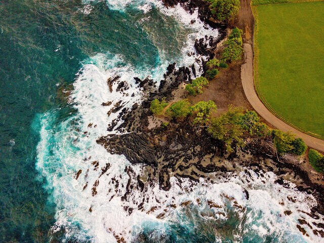 Aerial shot of the turqoise waves crashing agaisnt lava rock, Maui, Hawaii. 