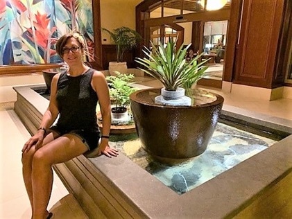 Hilton Grand Vacations Owner and Explorer, Irene, posing by a koi pond at Hilton Hawaiian Village on Oahu in Hawaii. 