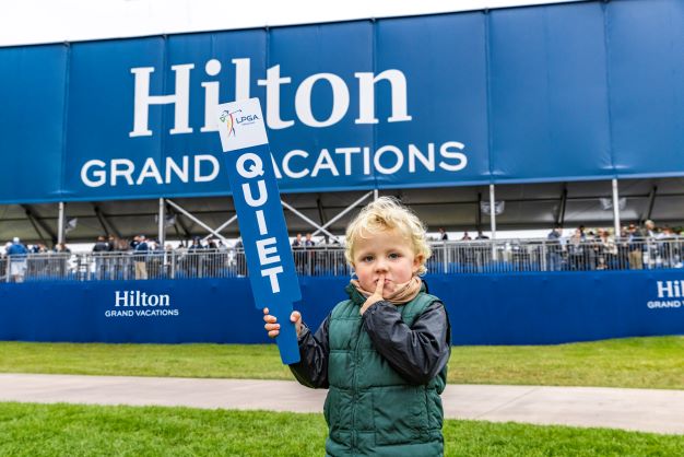 Little boy holding "quiet" sign at the Hilton Grand Vacations Tournament of Champions, Orlando, Florida. 