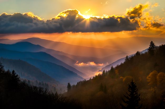 Gorgeous sunset vista glowing orange over the blueish haze of Great Smoky Mountains. 