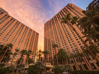 Angle looking up at resort The Boulevard, a Hilton Grand Vacations Club, in Las Vegas, Nevada, with palm trees and pastel skies