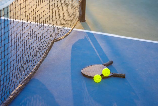 Pickleball paddles on pickleball court.