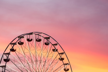 A beautiful view of the top of a ferris wheel as the sun sets