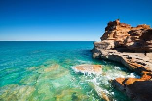 Beautiful coastal image, clear blue waters, blue skies, rocky cliffs. 