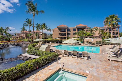 View of the manicured grounds, outdoor pool, hot tub and cabanas at The Bay Club, a Hilton Grand Vacations Club, Waikoloa, Hawaii