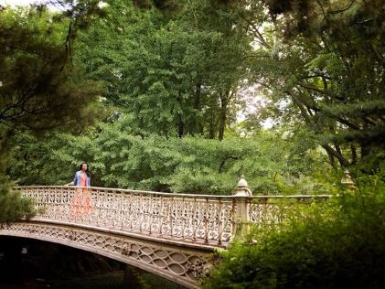 A woman standing on a bridge in Central Park in New York City